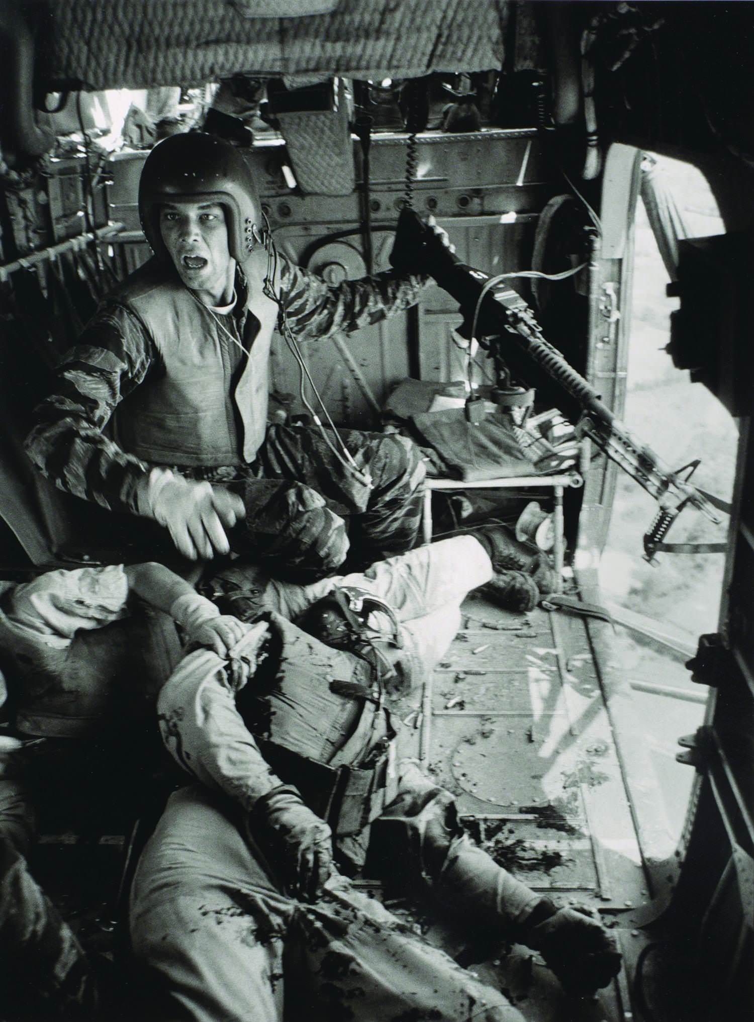 Crew Chief James Farley reacting when they cleared a hostile zone after 2 of his men have been shot during a mission in Vietnam in 1965. The one on the right, co-pilot Lieutenant Magel, sadly died before arriving back at base.