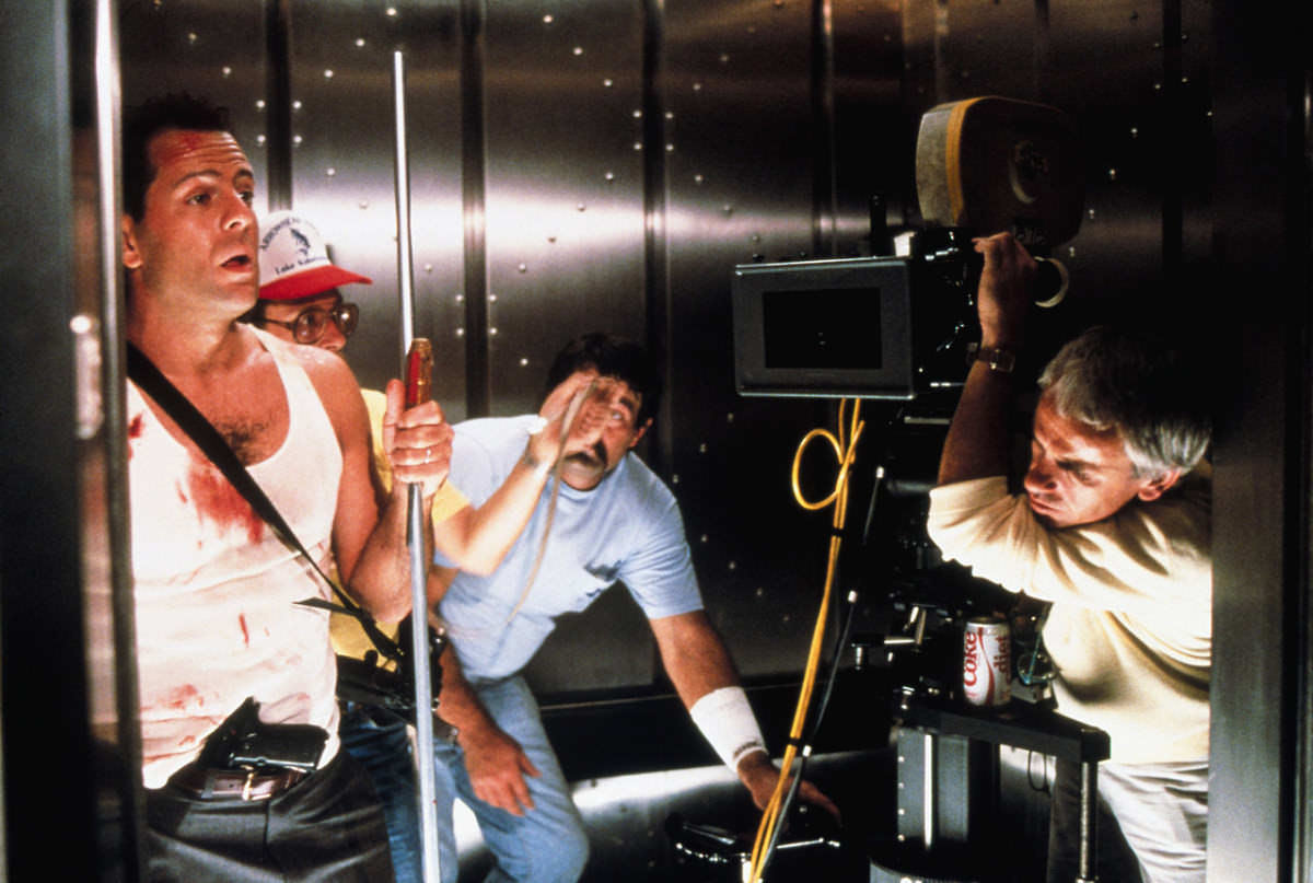 Crew members and Bruce Willis prepare for a scene in Die Hard (1988).