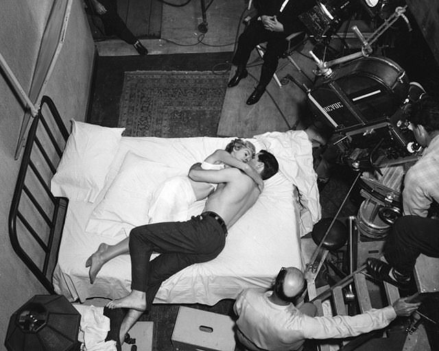 Janet Leigh and John Gavin doing a scene for the film Psycho (1960). Director Alfred Hitchcock is in the chair at the top of the picture.