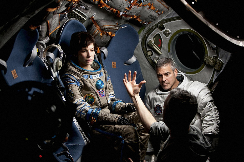 Director Alfonso Cuarón (bottom right) prepares Sandra Bullock and George Clooney for a scene in Gravity (2013).