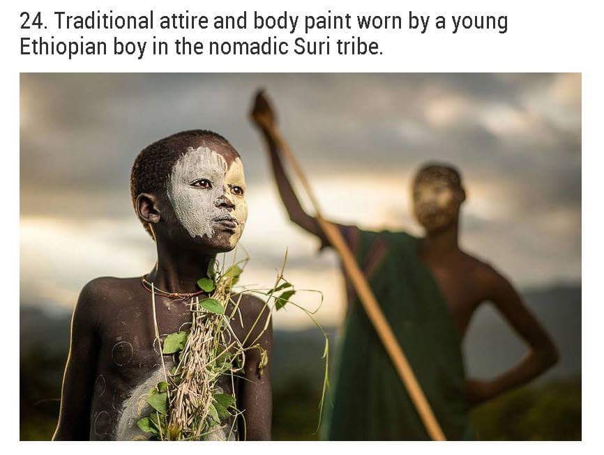 national geographic photos people - 24. Traditional attire and body paint worn by a young Ethiopian boy in the nomadic Suri tribe.