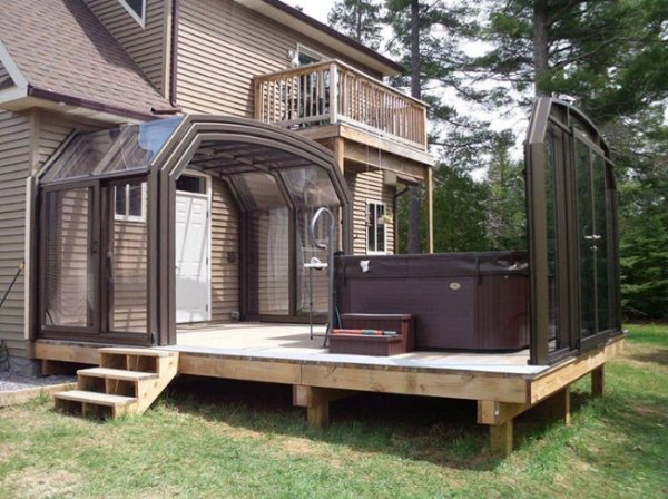 A veranda with a sliding roof and a hot tub.