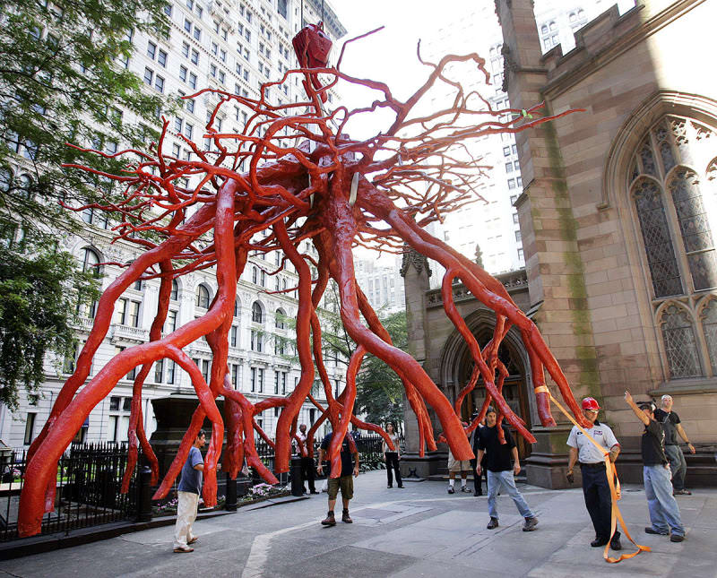 "Trinity Root" at Trinity Church in New York City.

Guided by workers, the "Trinity Root" sculpture is lowered into place by a crane in the Trinity Church yard of New York City in this photo. The 12.5-by-20-foot bronze sculpture, weighing 3 tons, memorializes the stump of a 70-year-old sycamore tree that shielded St. Paul's Chapel from falling debris on Sept. 11, 2001.