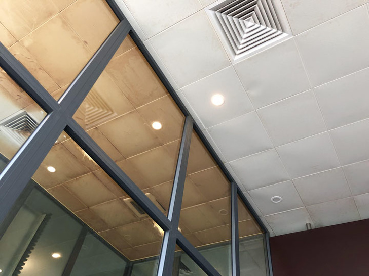 The ceiling tiles in the Da Nang airport smoking section vs the non-smoking section, Vietnam