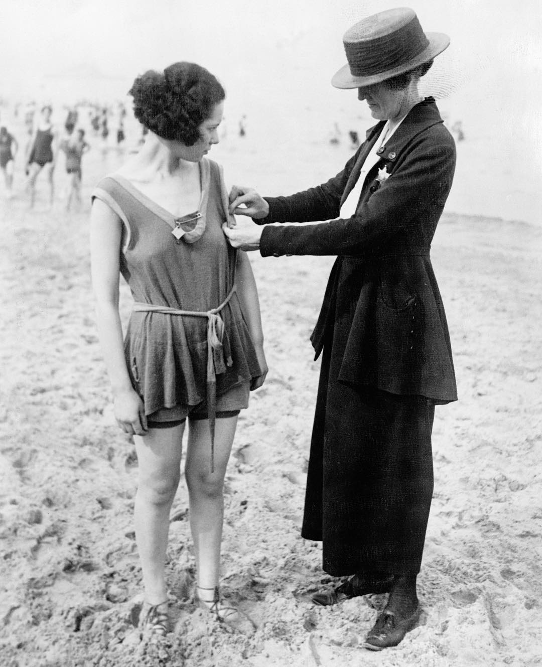 A Chicago policewoman checking for violations of the bathing suit-length laws 1921