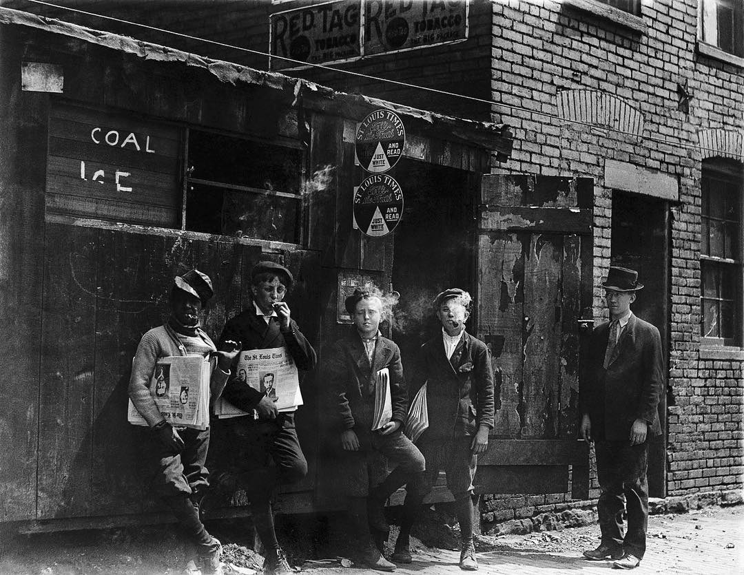11 a.m. Newsies at Skeeter’s Branch, Jefferson near Franklin. They were all smoking. 1910, St. Louis, Missouri.
