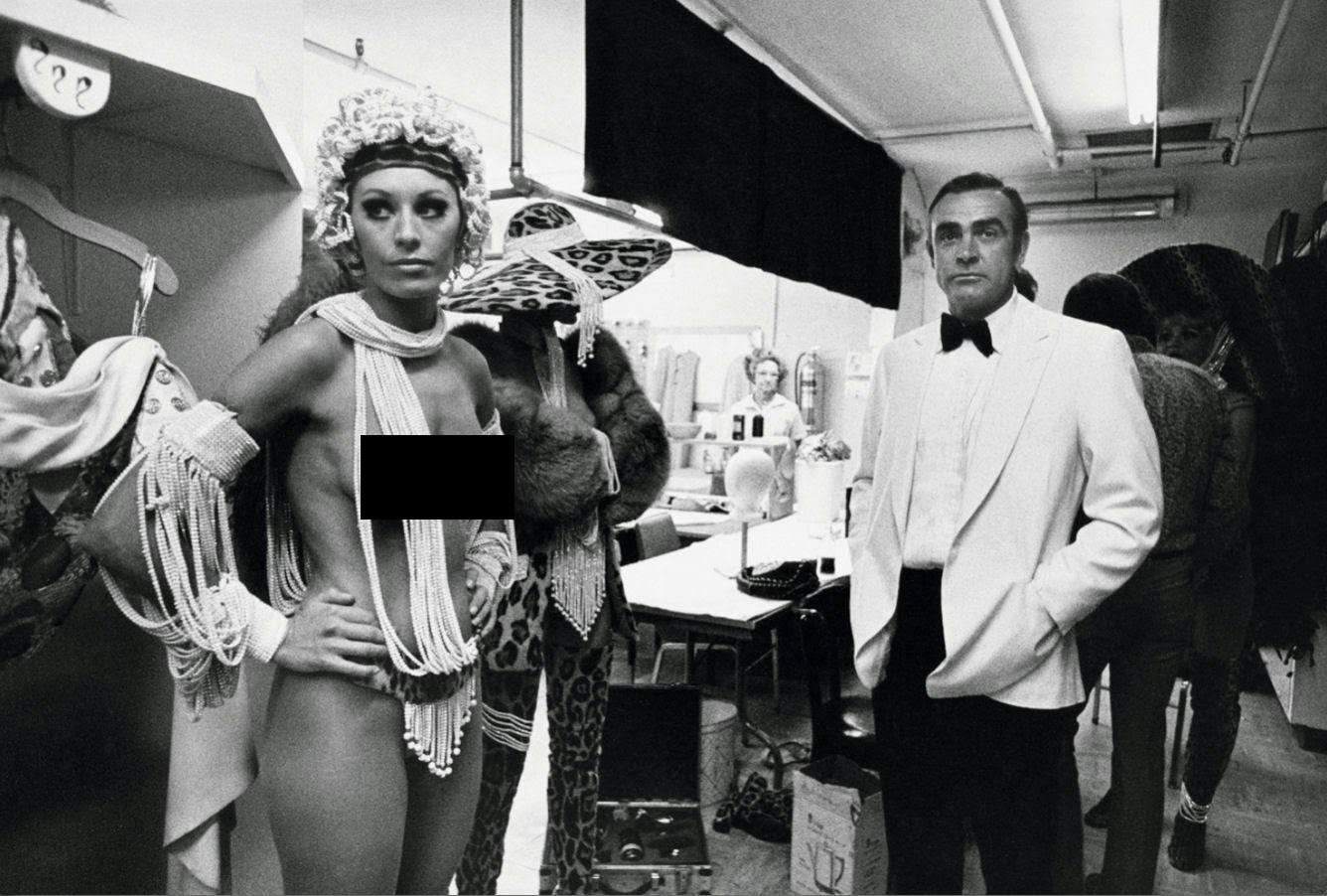 Sean Connery casually awaiting a scene with a topless showgirl who was an extra in Diamonds Are Forever (1971).