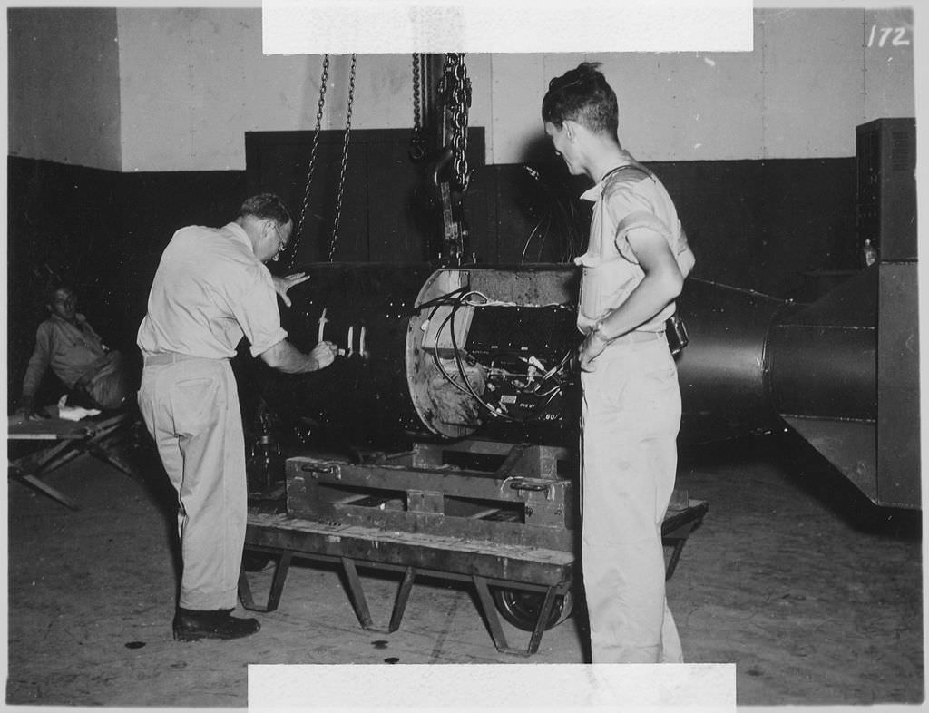 On the left, geophysicist and Manhattan Project participant Francis Birch marks the bomb unit that would become the  “Little Boy” atomic bomb, while Norman Ramsey, who would later win the Nobel Prize in Physics, looks on. This is one of the few photographs where the inside of the atomic bomb can be seen.