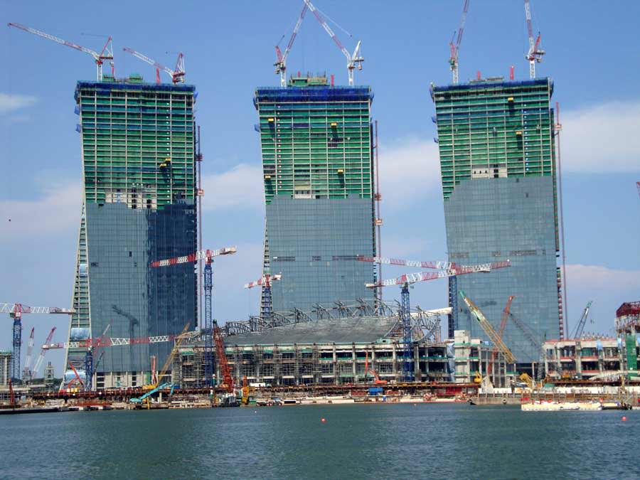 Marina Bay Sands under construction, Singapore. The gigantic complex comprising of a posh 5-star hotel, casino, convention center, luxury shopping center, and rooftop pool  would later become the world's second most expensive building at USD$5.50 billion, behind the Abraj Al Bait in Mecca, Saudi Arabia at USD$15 billion.