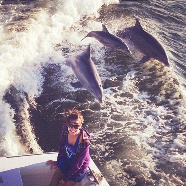 “I was on the boat with my family in Florida and sat on the edge of the boat to take a picture of me with the water and two dolphins and their baby jumped out of the water and this picture was caught at the perfect time. I have never seen this happen again before, especially in the wild. Pic was Fall 2012 in Tampa Bay Florida, taken by my brother, picture of me.”