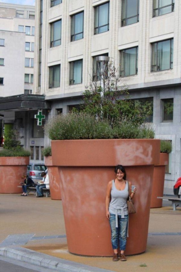 Woman posing next to huge potted plant