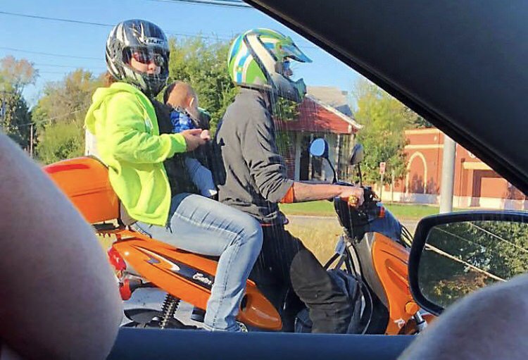 couple riding a motor with a baby
