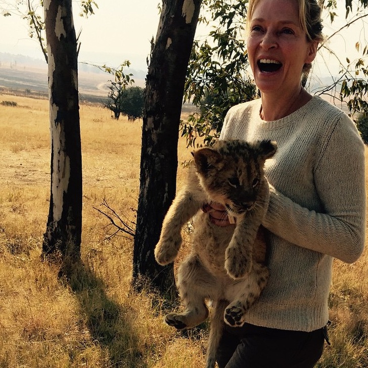 Uma Thurman is holding a lion cub.