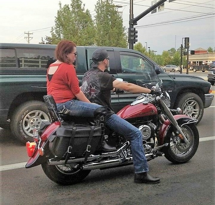 optical illusion of a biker with super long legged girlfriend