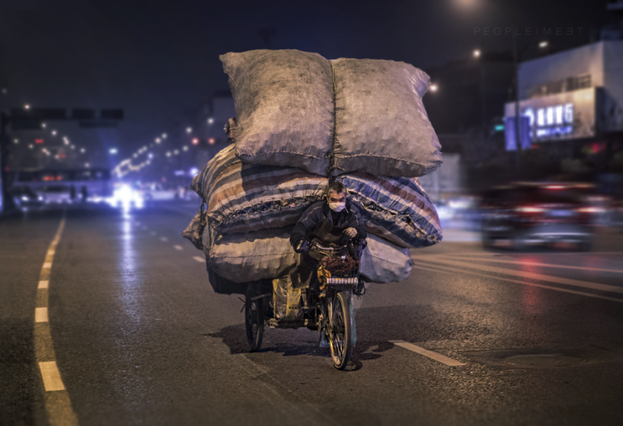 man carrying huge load on a bike