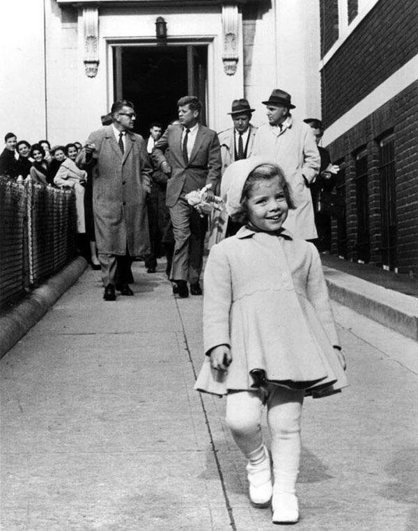 Caroline Kennedy walks ahead while her father carries her doll (1960).