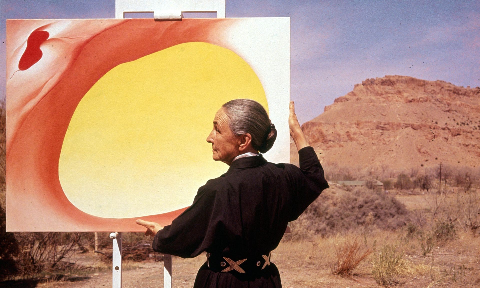 Georgia O’Keeffe adjusts a canvas from her Pelvis Series - Red With Yellow, in Albuquerque, New Mexico, in 1960. Photograph Tony Vaccaro-Getty Images.