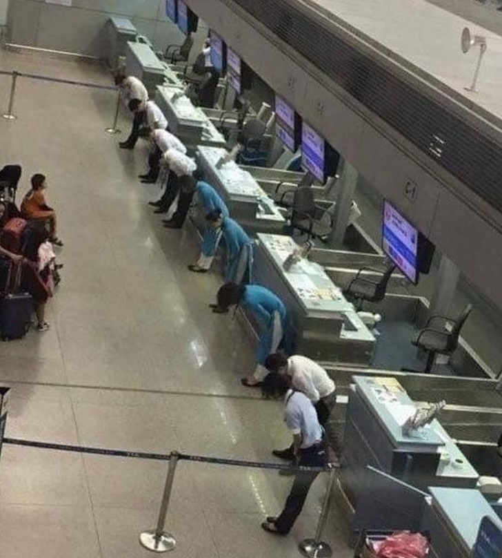 Airline employees bow to the passengers to apologize for a delayed flight.