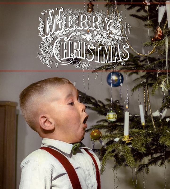 A boy blowing out a Christmas tree candle