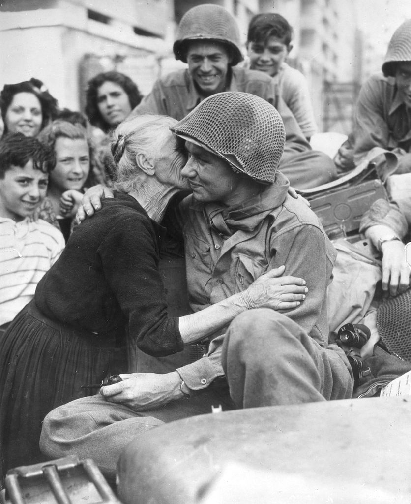 An old Italian woman shows her gratitude to one of the American soldiers following the liberation of Italy, 1945