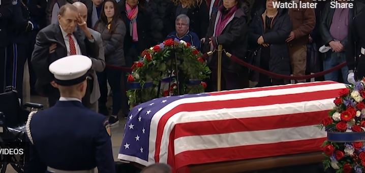 95-year-old former Senator Bob Dole helped out of wheelchair to give a final salute to fellow WWII vet George H.W. Bush