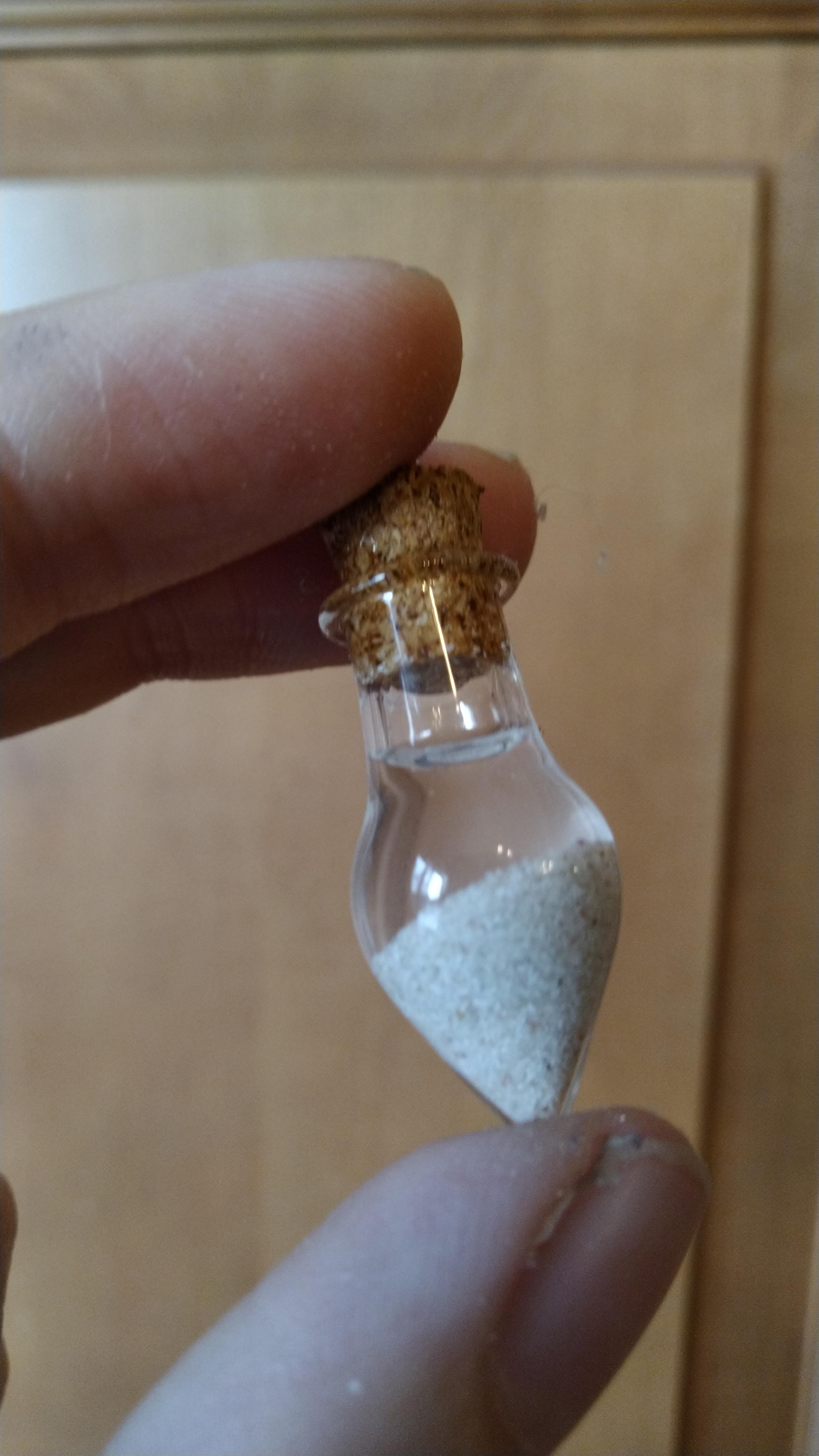work meme of a tiny vial of sand and ocean water that looks like a butt plug