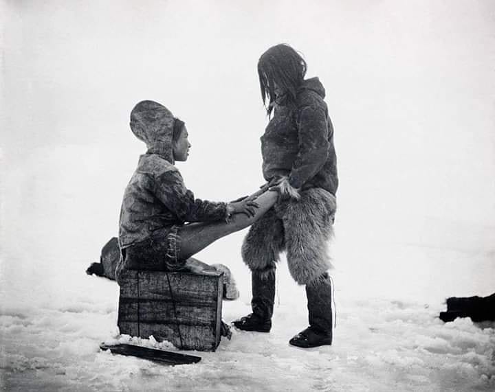 An Inuit man warms up his wife’s feet in Greenland, 1890s.