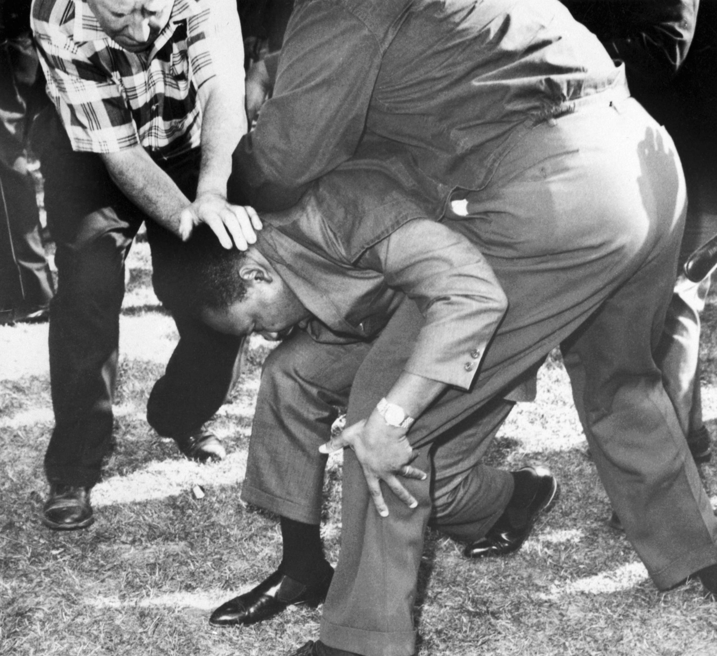Martin Luther King Jr. was shielded by his aides from a a mob of hostile whites after being struck by a rock to his head, while leading the march with civil rights demonstrators to protest housing discrimination in Chicago, Illinois. August 5, 1966