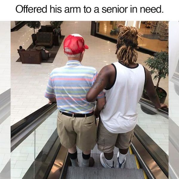 young man helps elderly man on escalator - Offered his arm to a senior in need.