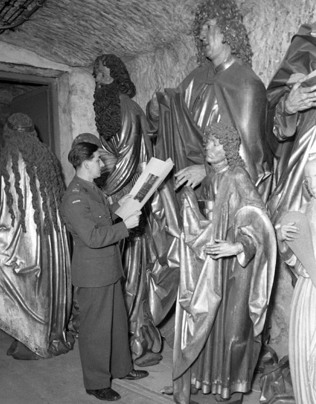 US officer at basment of Nuremburg castle next to the 500 years old statutes robbed by Nazis from Krakow’s St. Mary Cathedral, 1945
