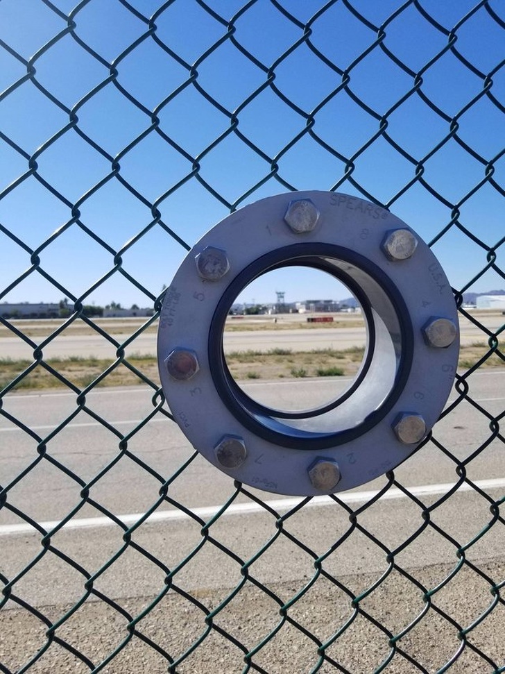 This airport put holes in the fence for photographers.