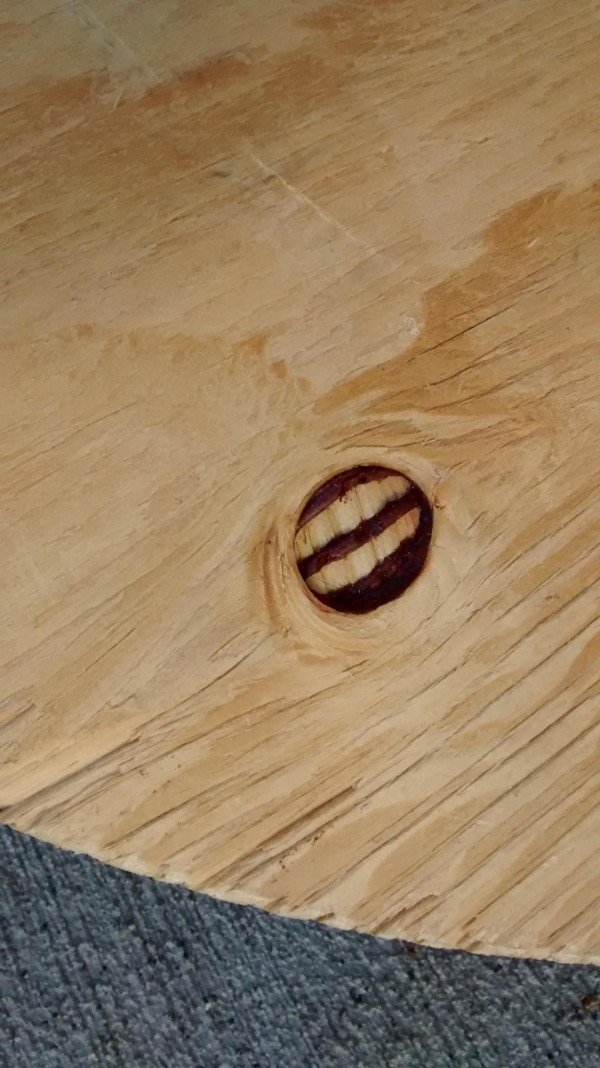 This plywood knothole looks like it has teeth.