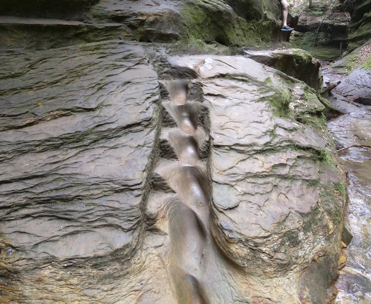 A staircase carved in the stone wall above a creek