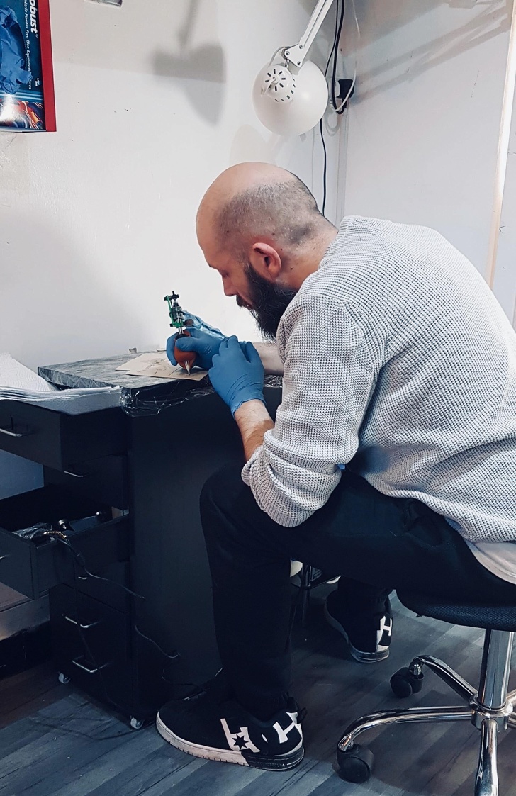 “After an 8 month apprenticeship, and numerous clean downs and set ups, this is me doing my first tattoo on some fake skin. It is what it is but I couldn’t be happier. I earned this.”