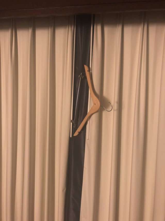 If the curtains in a hotel room don’t close all the way, keep the light of day from seeping in by clipping them closed with a hanger.