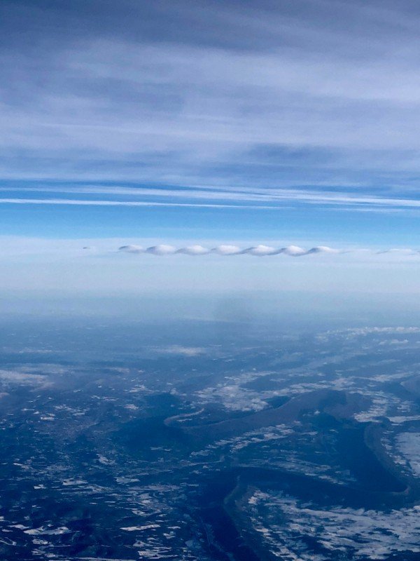 This funky little ribbon cloud outside my plane window.