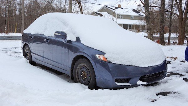 A little bit of snow fell while his car was parked.