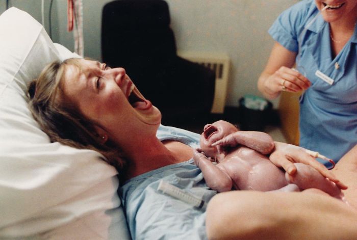 Wife's face after husband faints at the sight of his newborn son.