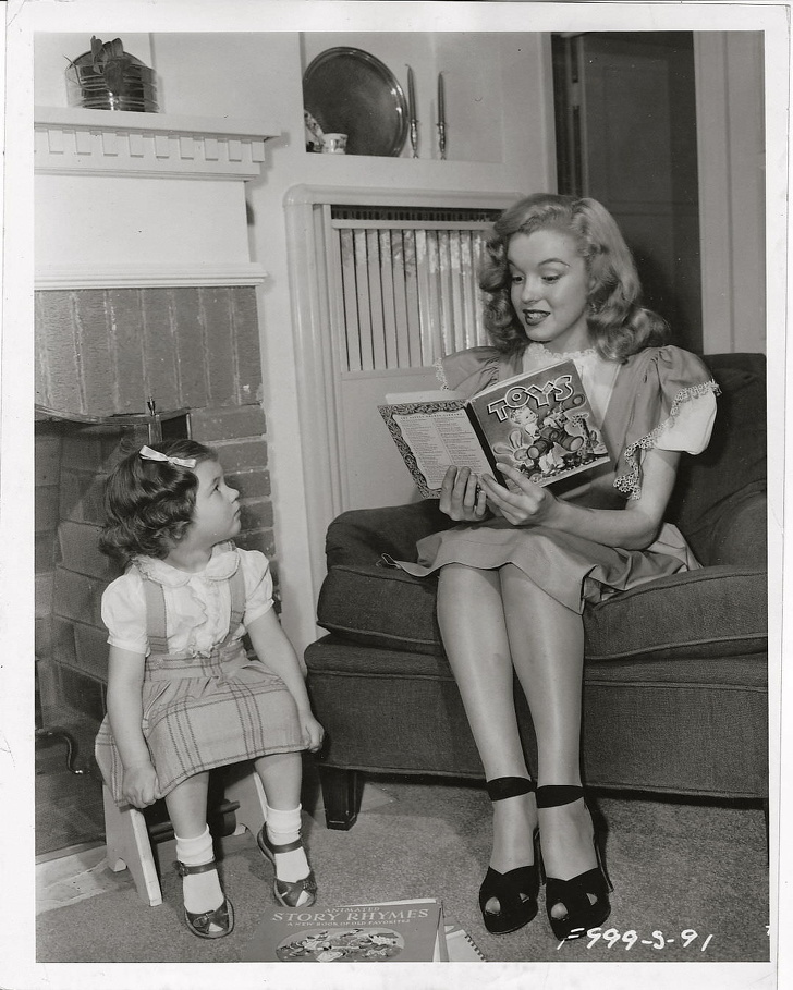 A young Marilyn Monroe babysitting a studio worker’s kid.