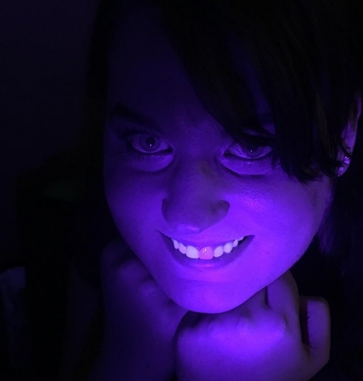 Fake teeth don't glow under black light.