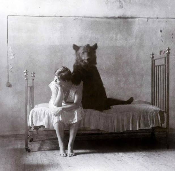 historical photo of girl with bear on bed