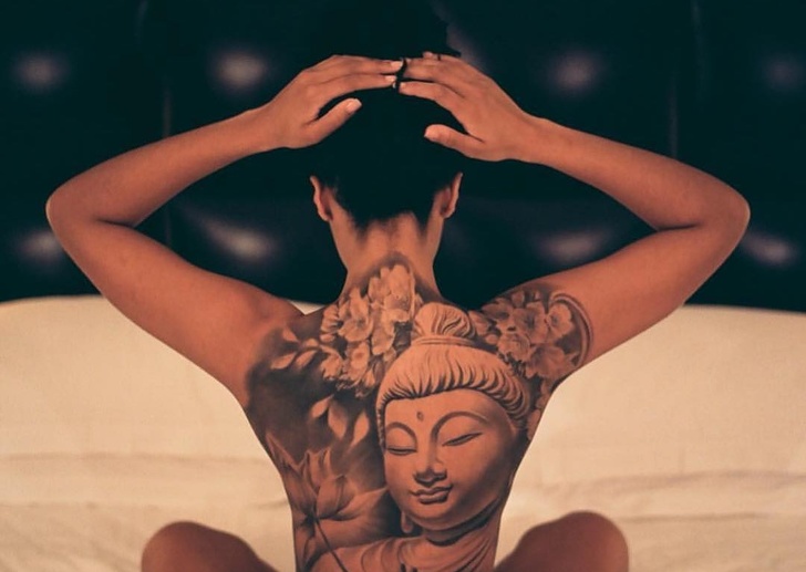 Beautiful tattoo of Buddha on a woman's back