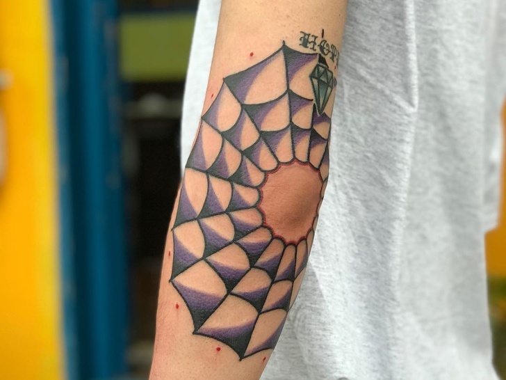Spiderweb tattoo on an elbow