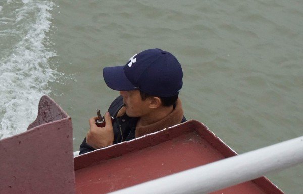 Smoking cigar through a pipe.