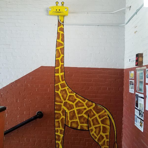 A school painted a giraffe with lights for the head.