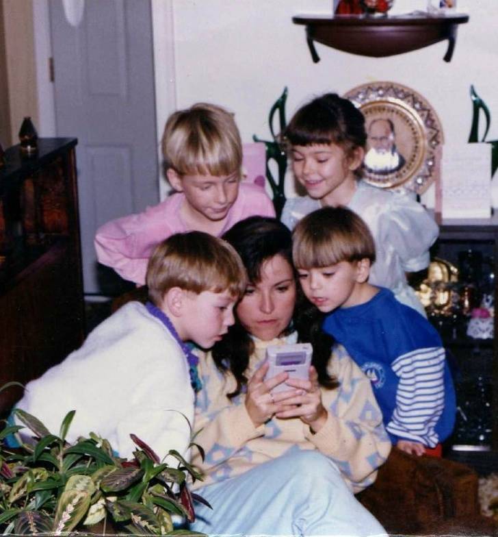 Mom helping her kids get through a hard level of Super Mario Land.