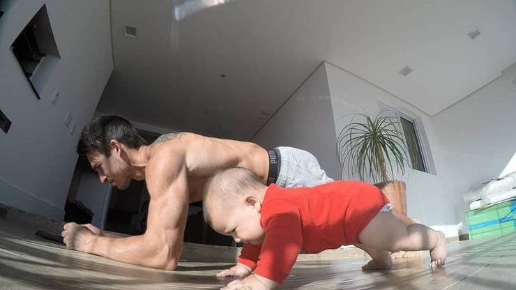 Baby wants to be as strong as his dad.
