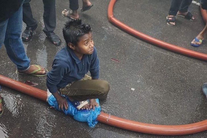 Kid stops a leak in a fire hose.