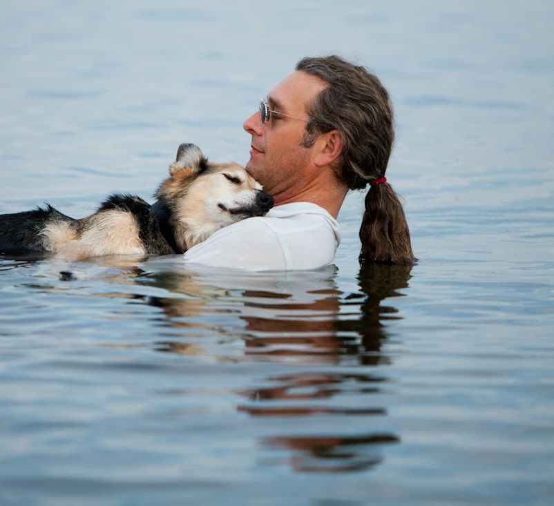 Man swims with his dog to relieve its arthritis pain.