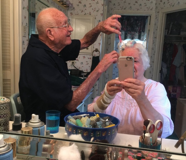 Old man doing his wife's hair.